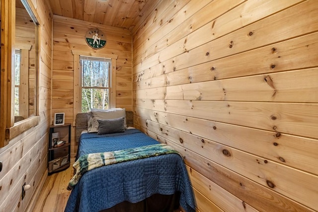 bedroom with wood-type flooring, wooden walls, and wood ceiling