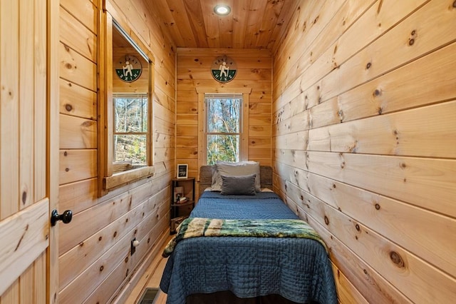 bedroom with wooden walls and wooden ceiling