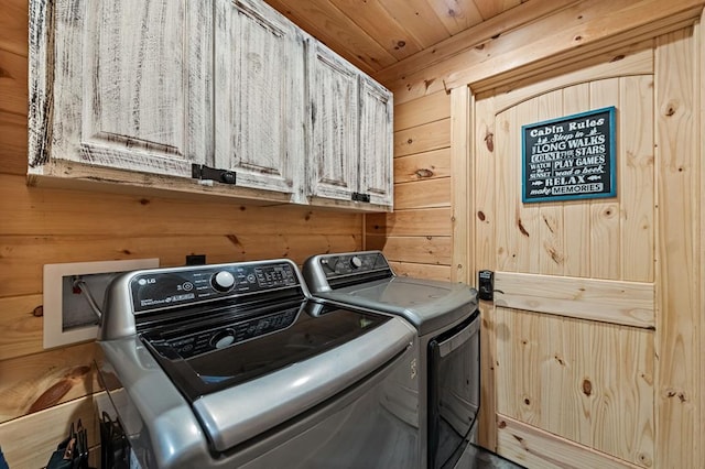 washroom featuring cabinets, washing machine and dryer, wooden ceiling, and wooden walls