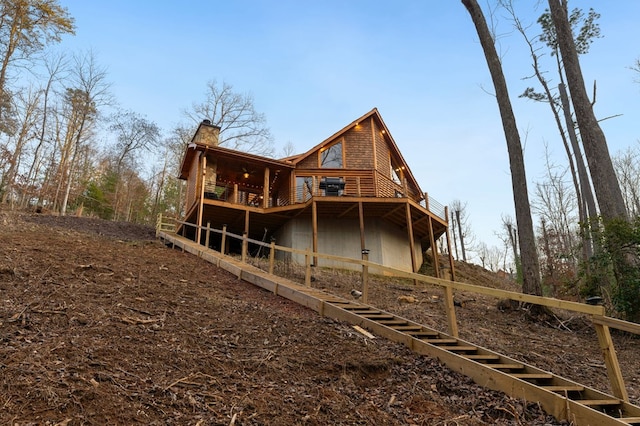 rear view of property featuring a wooden deck