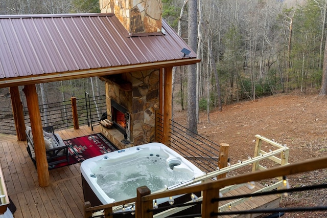 wooden deck with a fireplace and a hot tub