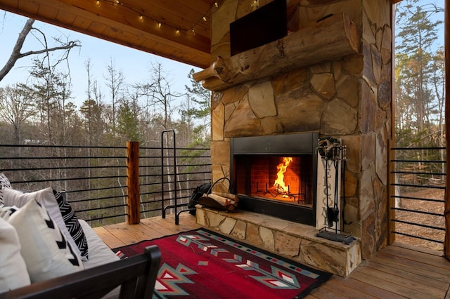 wooden terrace with an outdoor stone fireplace