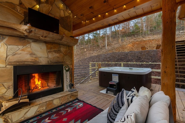 deck featuring a hot tub and an outdoor living space with a fireplace