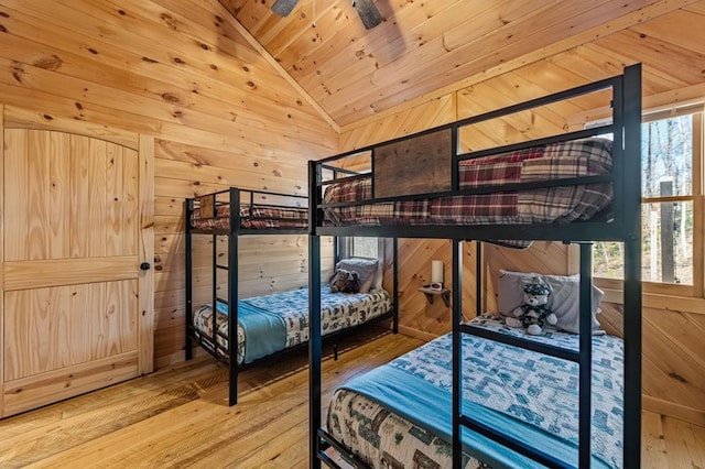 bedroom with vaulted ceiling, wood-type flooring, wooden ceiling, and wooden walls