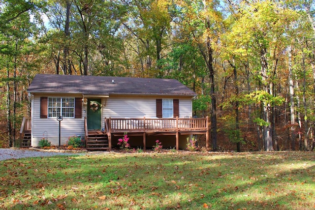 view of front facade with a wooden deck and a front yard