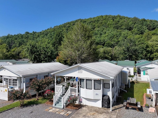 manufactured / mobile home with metal roof and a forest view