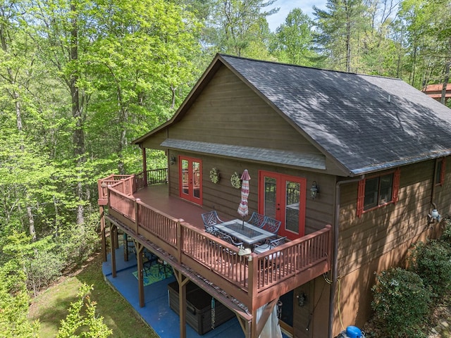 back of house featuring a shingled roof, a wooden deck, and french doors