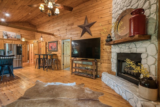 living area featuring light wood-style floors, ceiling fan, wooden walls, high vaulted ceiling, and wood ceiling