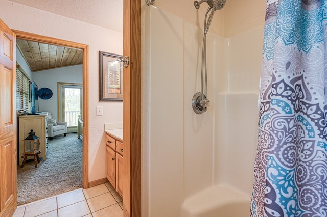 full bath featuring tile patterned flooring, vaulted ceiling, vanity, a textured wall, and a shower with shower curtain