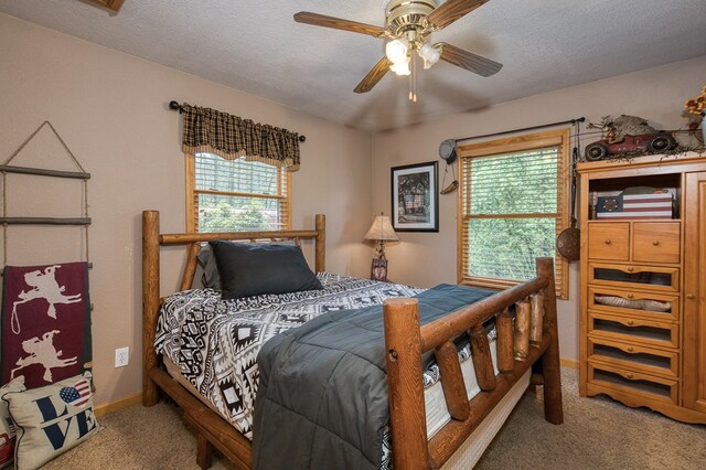 bedroom featuring baseboards, multiple windows, ceiling fan, and light colored carpet