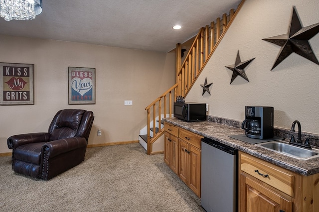 kitchen featuring black microwave, dark countertops, refrigerator, light colored carpet, and a sink