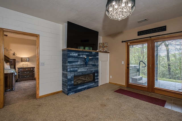 unfurnished living room with a chandelier, visible vents, a fireplace, lofted ceiling, and carpet