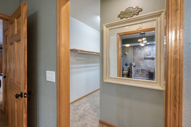 hallway with carpet flooring and baseboards