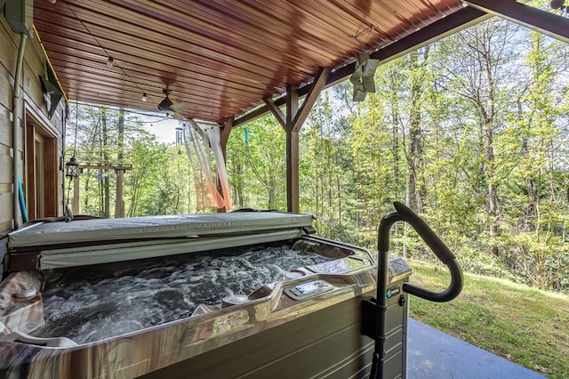 view of patio featuring ceiling fan and a wooded view