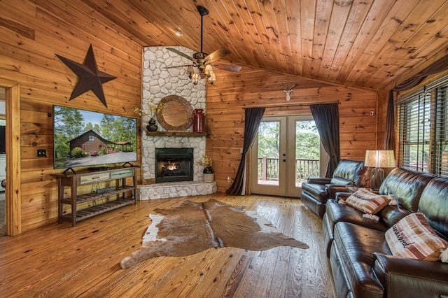 living room with wood ceiling, french doors, wood walls, wood-type flooring, and lofted ceiling