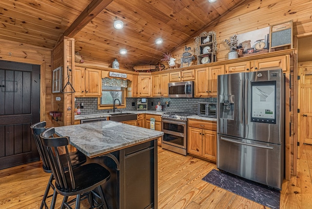 kitchen featuring a sink, appliances with stainless steel finishes, light wood-style floors, and backsplash