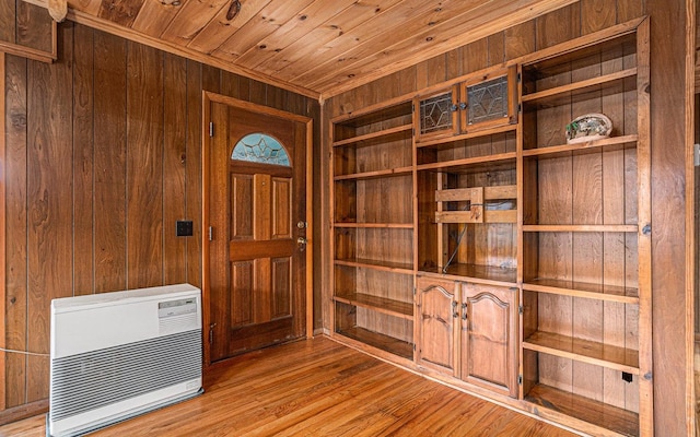 interior space featuring heating unit, wooden ceiling, light hardwood / wood-style floors, and wood walls