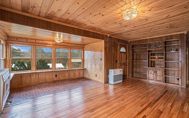 interior space with wood walls, plenty of natural light, and hardwood / wood-style flooring