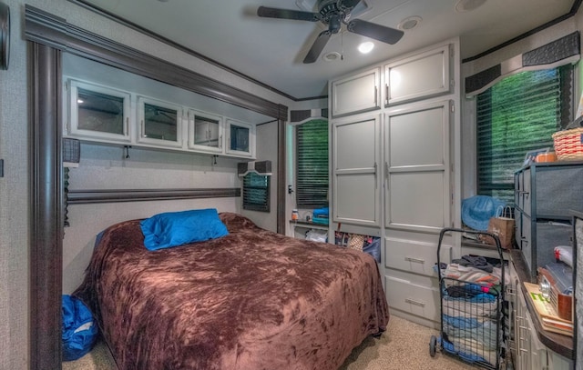 bedroom with crown molding, light colored carpet, and ceiling fan