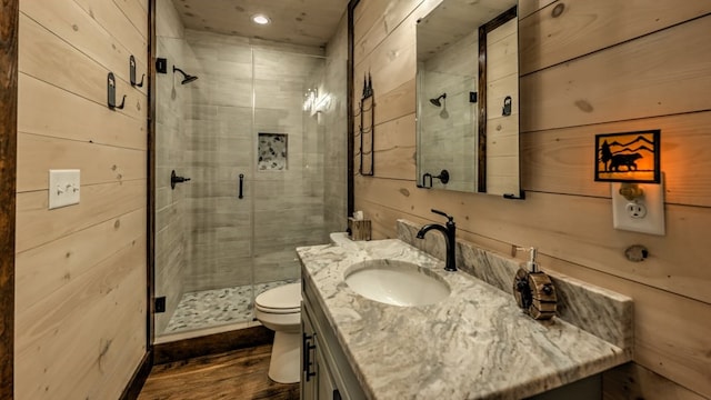 full bathroom with a stall shower, vanity, toilet, wood finished floors, and recessed lighting