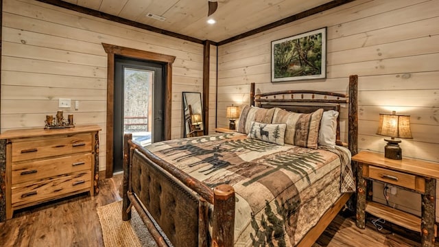 bedroom featuring wooden walls, wooden ceiling, wood finished floors, and access to outside
