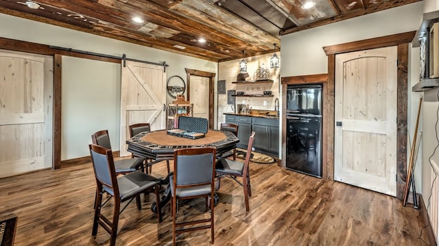 dining area featuring a barn door and dark wood-type flooring