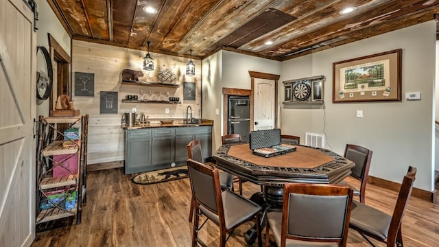 dining area featuring wet bar, baseboards, dark wood finished floors, recessed lighting, and wooden ceiling