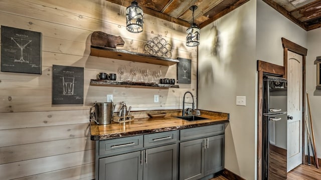 kitchen featuring a sink, open shelves, gray cabinets, wood finished floors, and wood ceiling