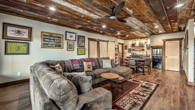 living area featuring a barn door, dark wood-style floors, baseboards, and recessed lighting