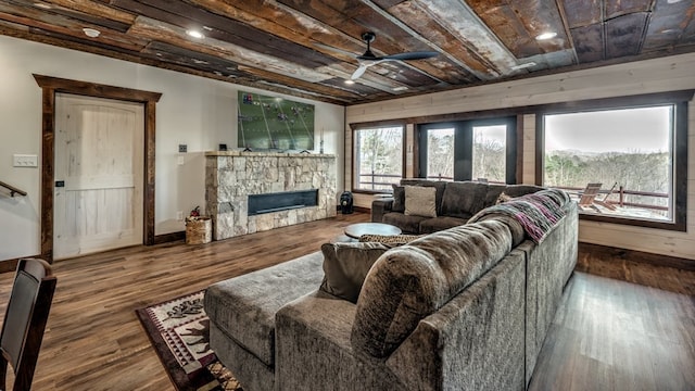 living room with ceiling fan, a fireplace, wood finished floors, baseboards, and wood ceiling