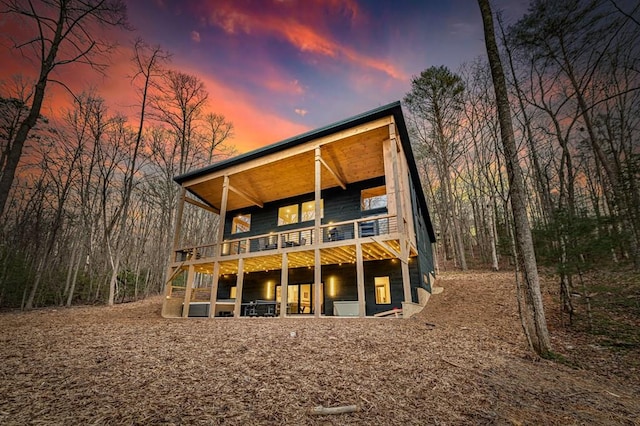 back of property at dusk with a balcony