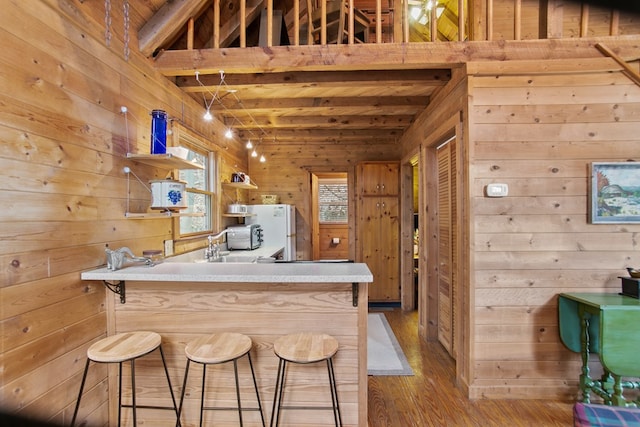 bar featuring beam ceiling, a towering ceiling, wood walls, white fridge, and light wood-type flooring