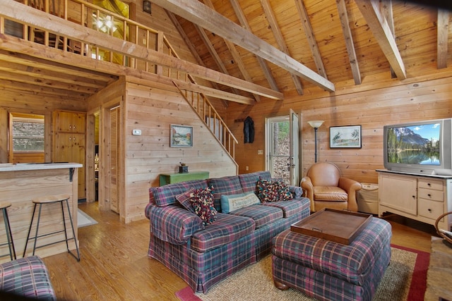 living room featuring wood ceiling, beamed ceiling, and wood walls