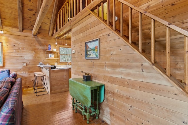 interior space featuring beam ceiling, hardwood / wood-style floors, wood ceiling, and wood walls