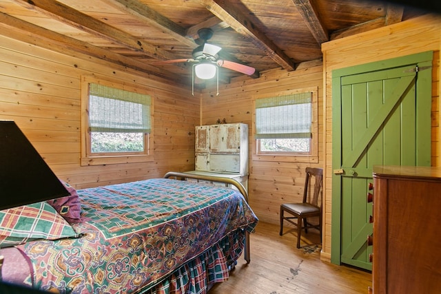 bedroom featuring beam ceiling, wooden ceiling, wood walls, and light wood-type flooring