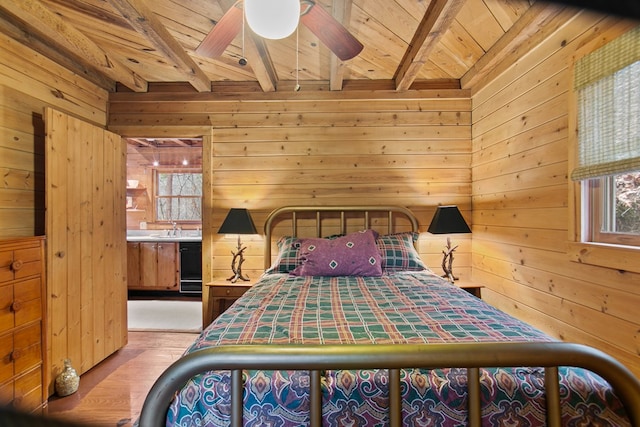 bedroom featuring light hardwood / wood-style flooring, wooden walls, wooden ceiling, and beamed ceiling