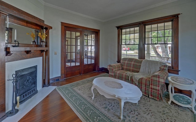 living room featuring crown molding, french doors, wood finished floors, and a healthy amount of sunlight