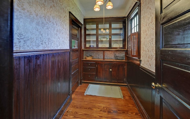 interior space with wallpapered walls and a wainscoted wall