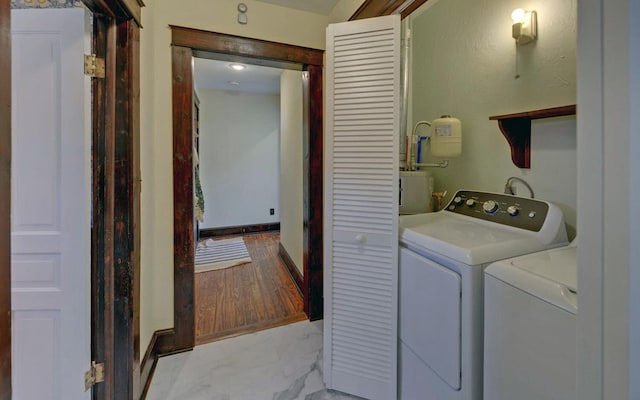 clothes washing area with independent washer and dryer, laundry area, and marble finish floor