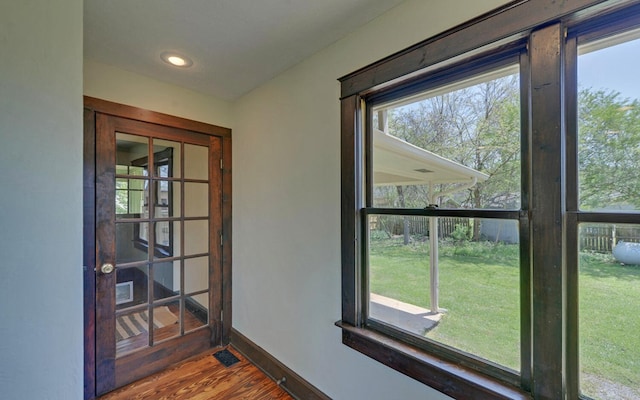 doorway featuring wood finished floors, baseboards, and recessed lighting