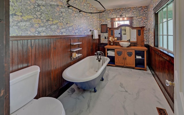 full bath with toilet, wainscoting, visible vents, and a wealth of natural light