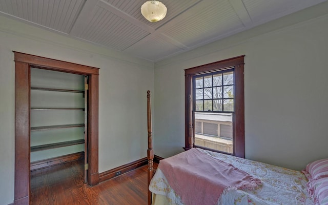 bedroom with coffered ceiling, baseboards, dark wood-style floors, and beam ceiling