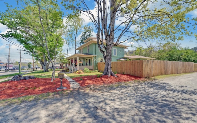 view of front facade with a porch and fence