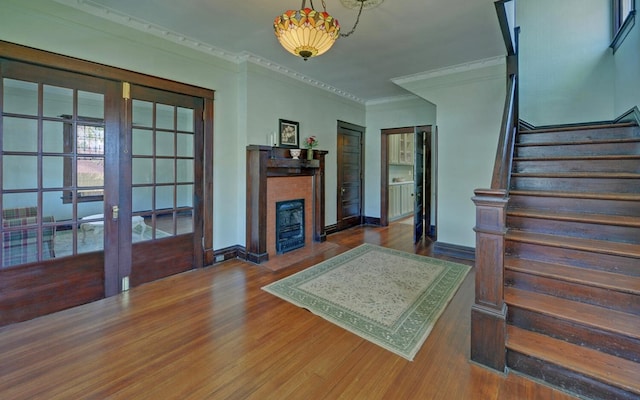 living area with a fireplace with flush hearth, stairway, and wood finished floors