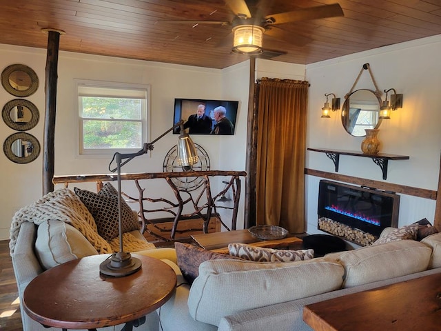 living area featuring wood finished floors, wood ceiling, and a glass covered fireplace