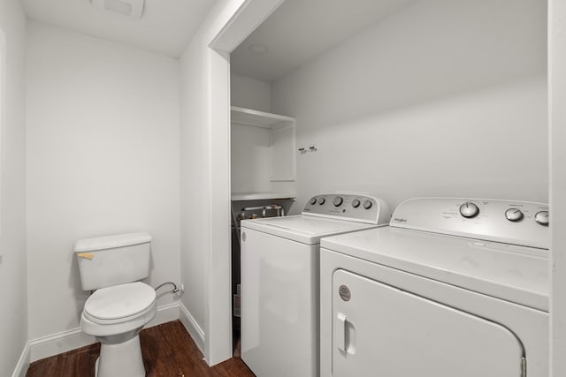 clothes washing area featuring baseboards, laundry area, dark wood-style flooring, and washer and dryer