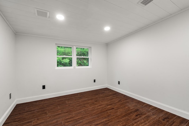 spare room featuring baseboards, ornamental molding, dark wood-style flooring, and visible vents