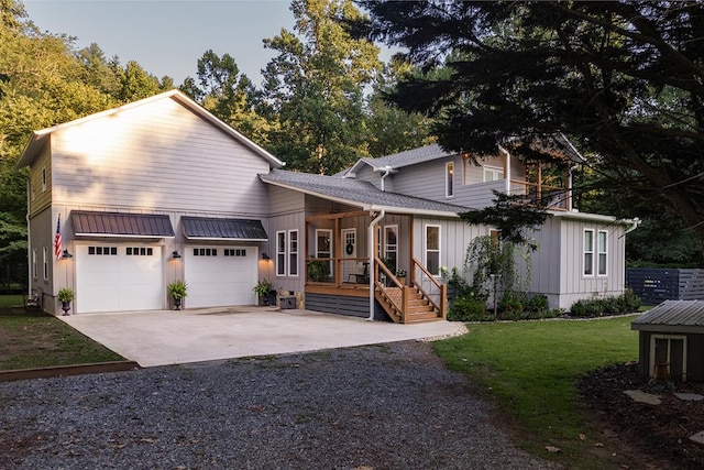 view of front facade featuring covered porch, a garage, and a front yard