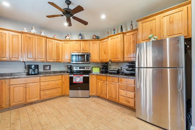 kitchen with dark stone counters, light hardwood / wood-style floors, appliances with stainless steel finishes, and ceiling fan