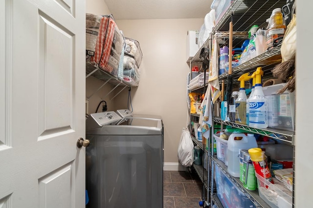 laundry area with washer and clothes dryer and dark tile patterned flooring